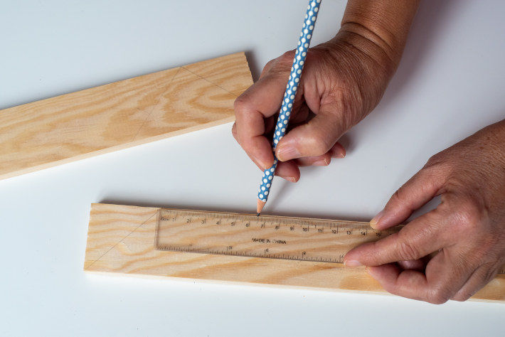 Oznaczanie ołówkiem punktu na drewnianej listwie